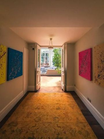 Flur mit bunten Gemälden führt zu einem hellen Innenhof