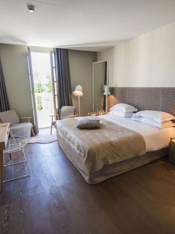 Geräumiges, modern eingerichtetes Hotelzimmer mit Schreibtisch und Sesseln