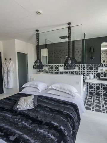 Luxus-Suite mit stilvoller, monochromer Einrichtung und zwei Bademänteln