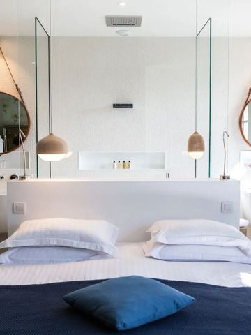 Modernes Badezimmer mit weißen Design-Elementen und Spiegeln
