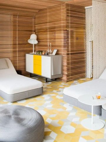 Moderne Lounge mit zentralem Liegenbereich und grafischen Holzelementen