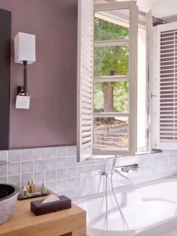 Luxuriöses Badezimmer mit freistehender Badewanne und großem Fenster