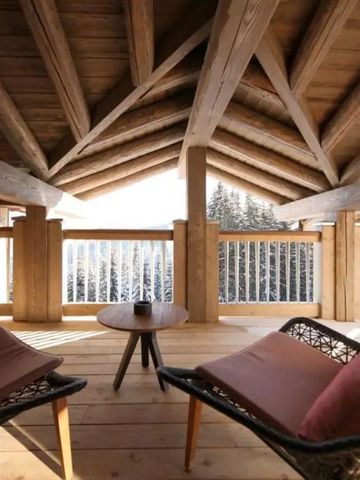 Gemütlicher Balkon mit Holzdecke und Ausblick auf verschneite Landschaft