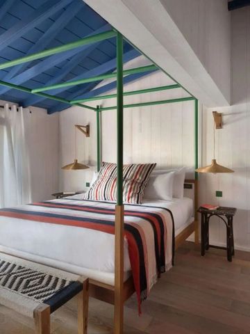 Schlafzimmer mit freiliegenden Balken und einem stilvollen Himmelbett