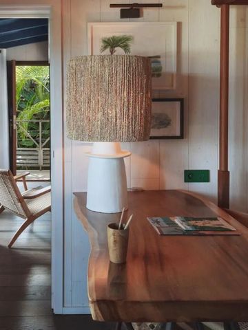 Holztisch mit Lampe neben einem offenen Raum mit Blick nach draußen