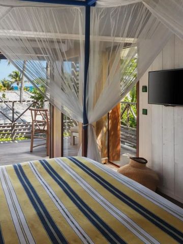 Zimmer mit Blick auf die Terrasse und das Meer im Hintergrund