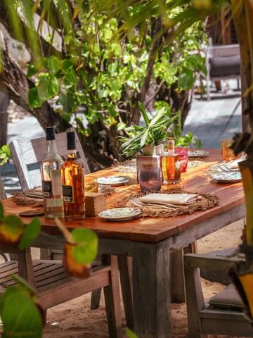 Rustikaler Holztisch im Freien mit gedecktem Tisch und grüner Umgebung