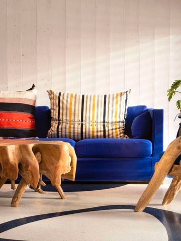 Elegante Lounge mit blauem Sofa und kunstvollen Holztischen