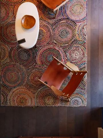 Bunte Teppichmuster und stilvolle Stühle aus der Vogelperspektive