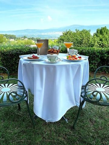 Gartenbereich mit gedecktem Tisch und zwei Stühlen.