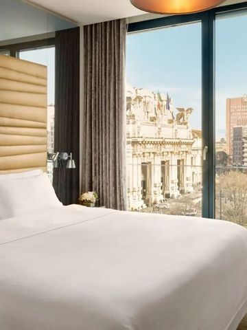 Hotelzimmer mit Panoramafenster und Blick auf urbanes Umfeld