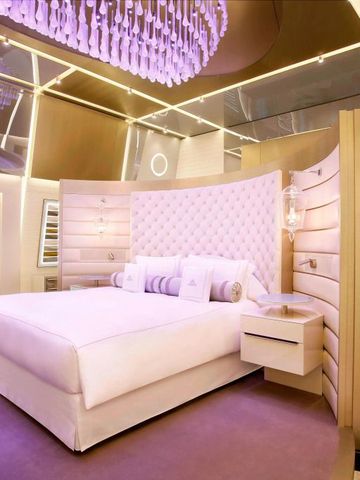 Luxuriöses Schlafzimmer mit futuristischer Decke und violetter Beleuchtung.