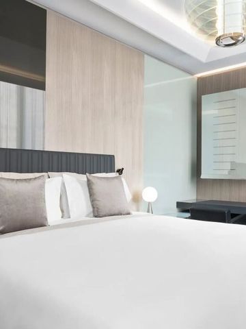 Hotelzimmer mit minimalistischem Design und eleganten Grautönen.