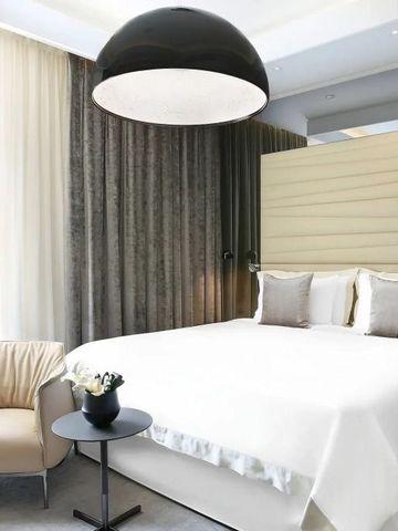 Geräumiges Schlafzimmer mit großer Deckenleuchte und komfortabler Sitzecke.