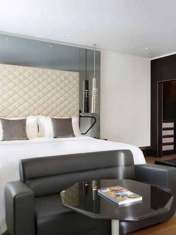 Luxuriöses Zimmer mit eleganter Wandgestaltung und funktionalem Sitzbereich.