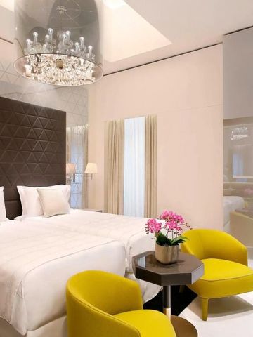 Luxuriöses Hotelzimmer mit Doppelbett und modernen gelben Sesseln