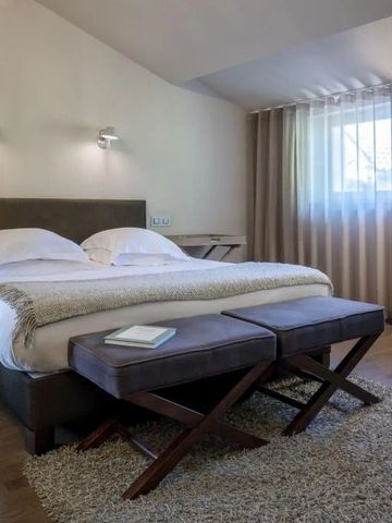 Modernes, gemütliches Schlafzimmer mit großem Bett und weichen Teppichen auf Holzboden.