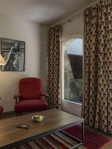 Gemütlicher Sitzbereich mit roten Sesseln und stilvollen Vorhängen vor einem großen Fenster.