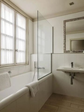 Badezimmer mit Badewanne und großem Spiegel