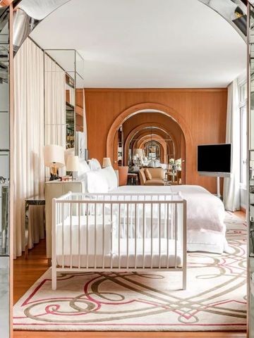 Hotelsuite mit Babybett und dekorativen Spiegelbögen