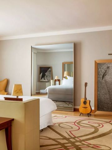 Hotelzimmer mit modernem Design, Spiegel und Gitarre.