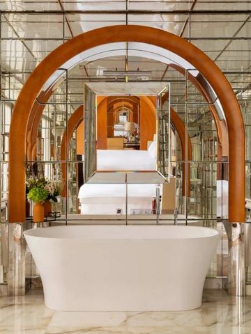 Spiegelndes Badezimmer mit freistehender Badewanne und architektonischem Detail.