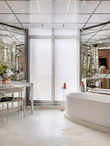 Luxuriöses Badezimmer mit freistehender Badewanne und Spiegelwänden