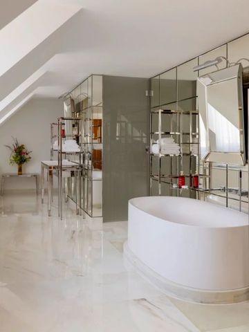 Geräumiges Badezimmer mit freistehender Badewanne und Spiegelregalen