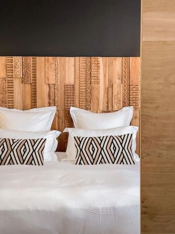 Elegantes Hotelzimmer mit Holzwand und stilvollen Kissen