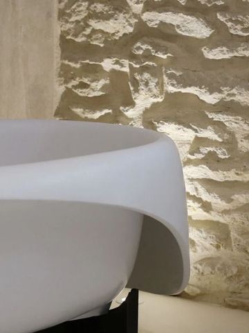 Moderne Badewanne vor rustikaler Steinwand