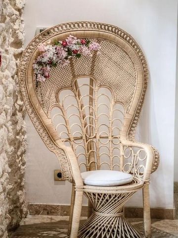 Geflochtener Stuhl mit Blumen dekoriert in heller Ecke