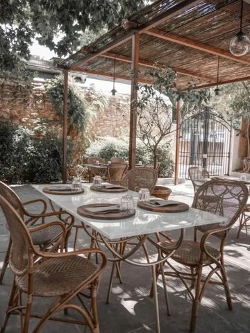 Gemütlicher Außen-Essbereich unter einem hölzernen Dach mit grünen Pflanzen