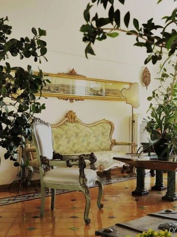 Eleganter Loungebereich mit antiken Möbeln und Pflanzen.