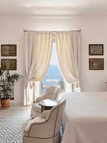 Geräumiges Zimmer mit eleganten Vorhängen und Balkon zum Meer.