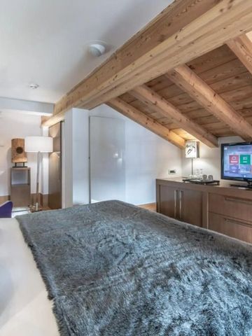 Gemütliches Zimmer mit Holzdecke und modernem Unterhaltungssystem