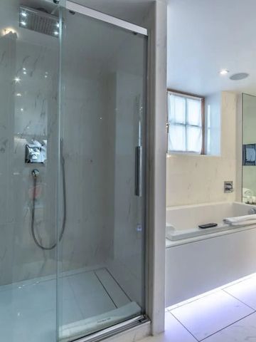 Modernes Badezimmer mit Glasdusche und großem Spiegel