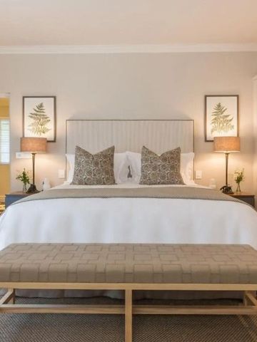 Geschmackvoll eingerichtetes Schlafzimmer mit Kunstwerken an der Wand