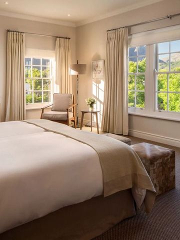 Helles, elegantes Schlafzimmer mit großem Fenster und Gartenblick.