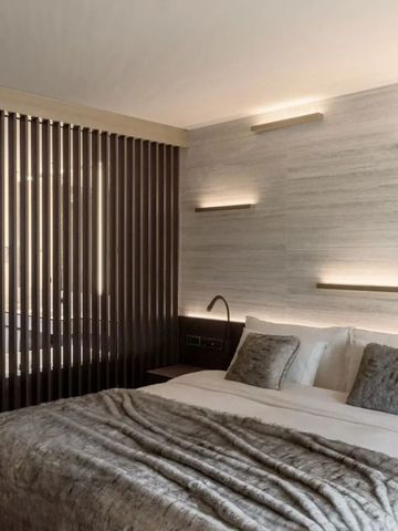 Modernes Schlafzimmer mit weichem Bett und dezenter Beleuchtung