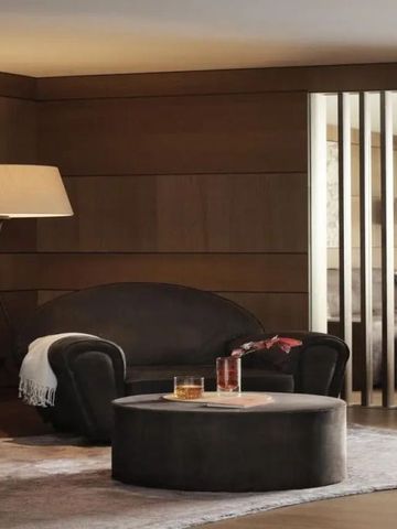 Elegante Lounge mit dunklen Sesseln und stimmungsvollem Licht