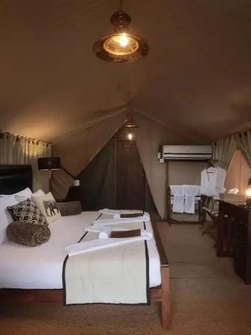 Luxuriöses Zeltzimmer mit eleganten Möbeln und einladendem Doppelbett