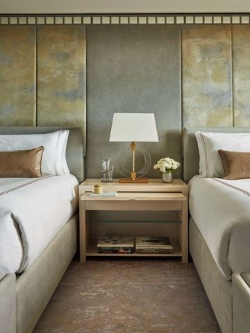 Zwei bequeme Betten mit stilvollen Lampen und modernem Design in einem Hotelzimmer