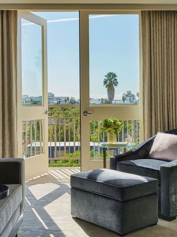 Sitzbereich mit stilvollem Sessel und Balkon mit sonniger Aussicht