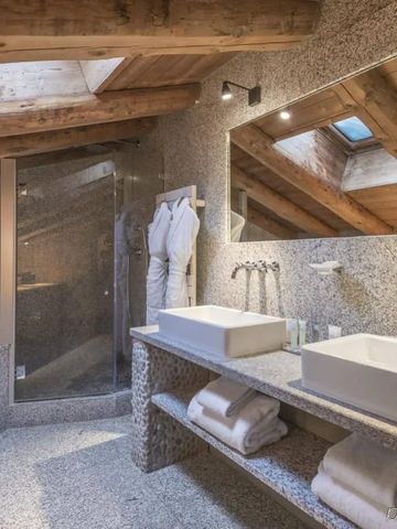 Elegantes Badezimmer mit freiliegenden Holzbalken und moderner Ausstattung