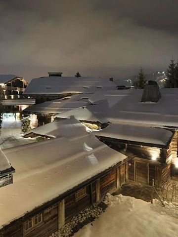 Verschneite Dächer und Gebäude bei Nacht im Alpenstil