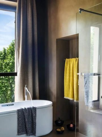 Helles Badezimmer mit freistehender Badewanne und großzügigem Fenster