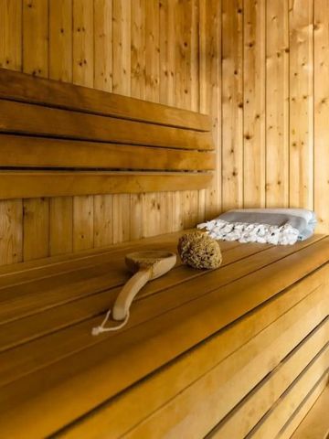 Leere Sauna mit Holzbänken und Saunasteinen