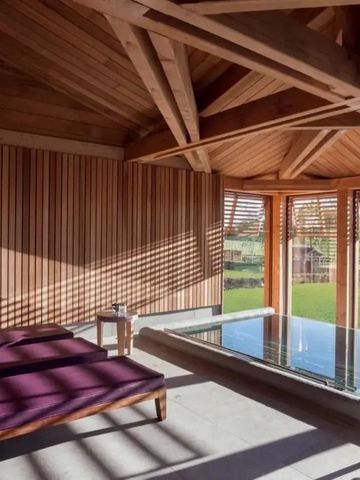 Innenpool mit Holzverkleidung und Blick ins Freie