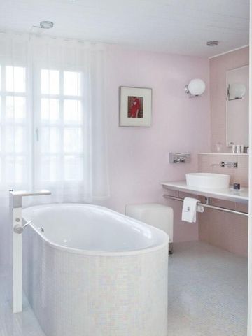 Modernes Badezimmer mit freistehender Badewanne und sanften Farben