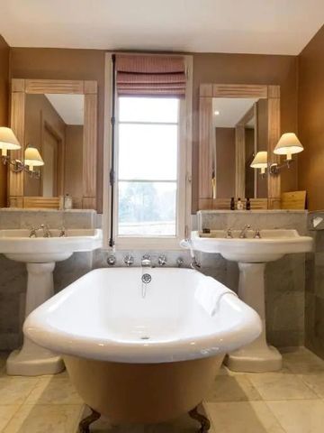 Klassisches Badezimmer mit freistehender Badewanne und zwei Waschbecken